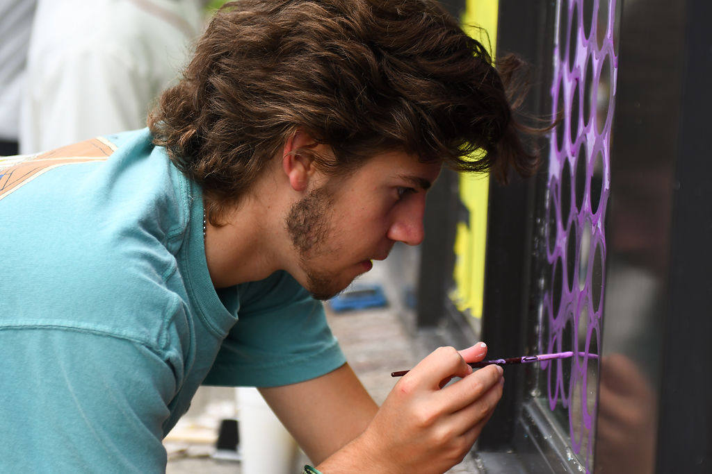 Chris Bonderer paints the windows of a store